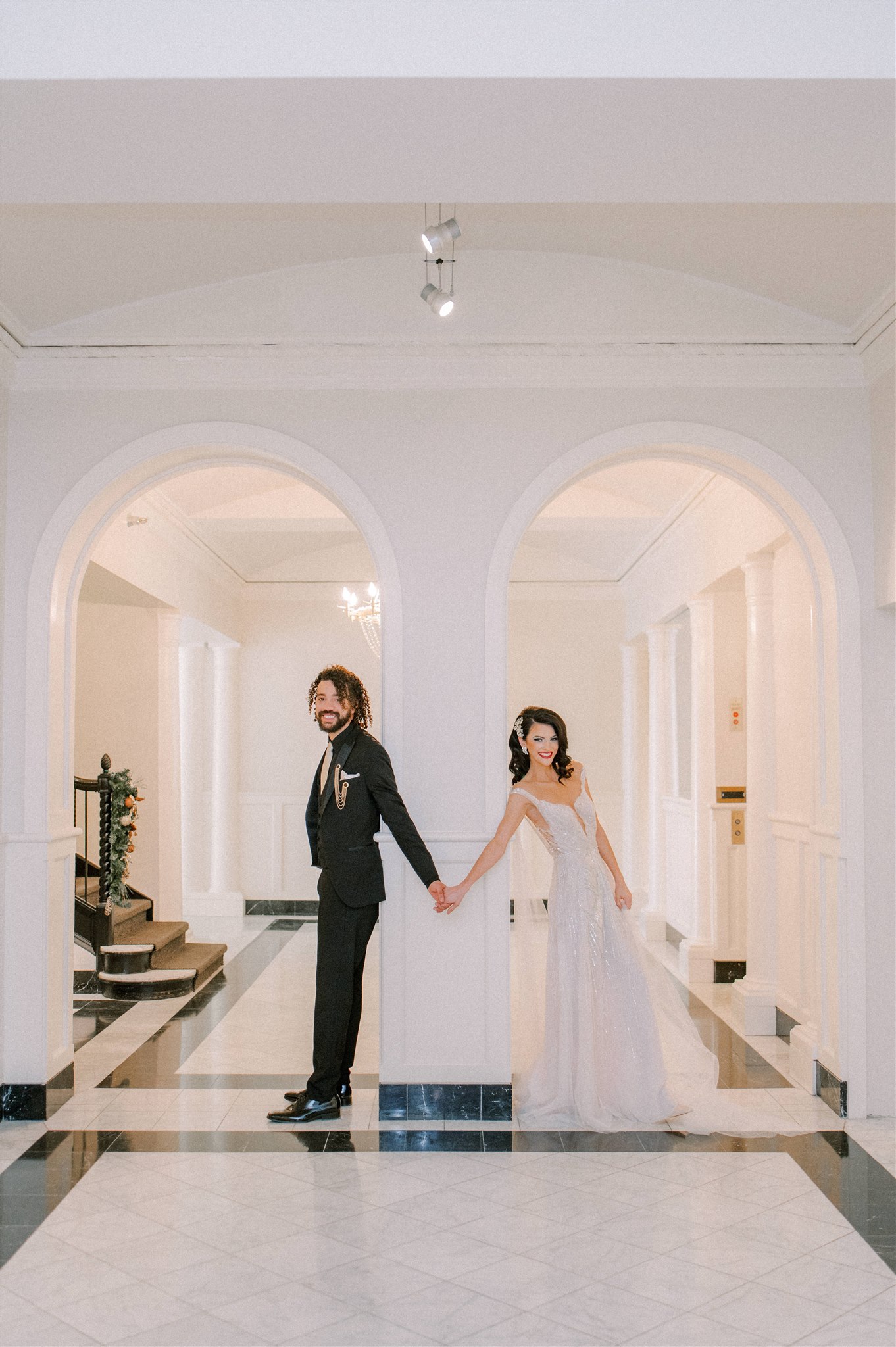 Bride and groom holding hands at Leo Room while getting ready to walk down the aisle gorgeous wedding photo